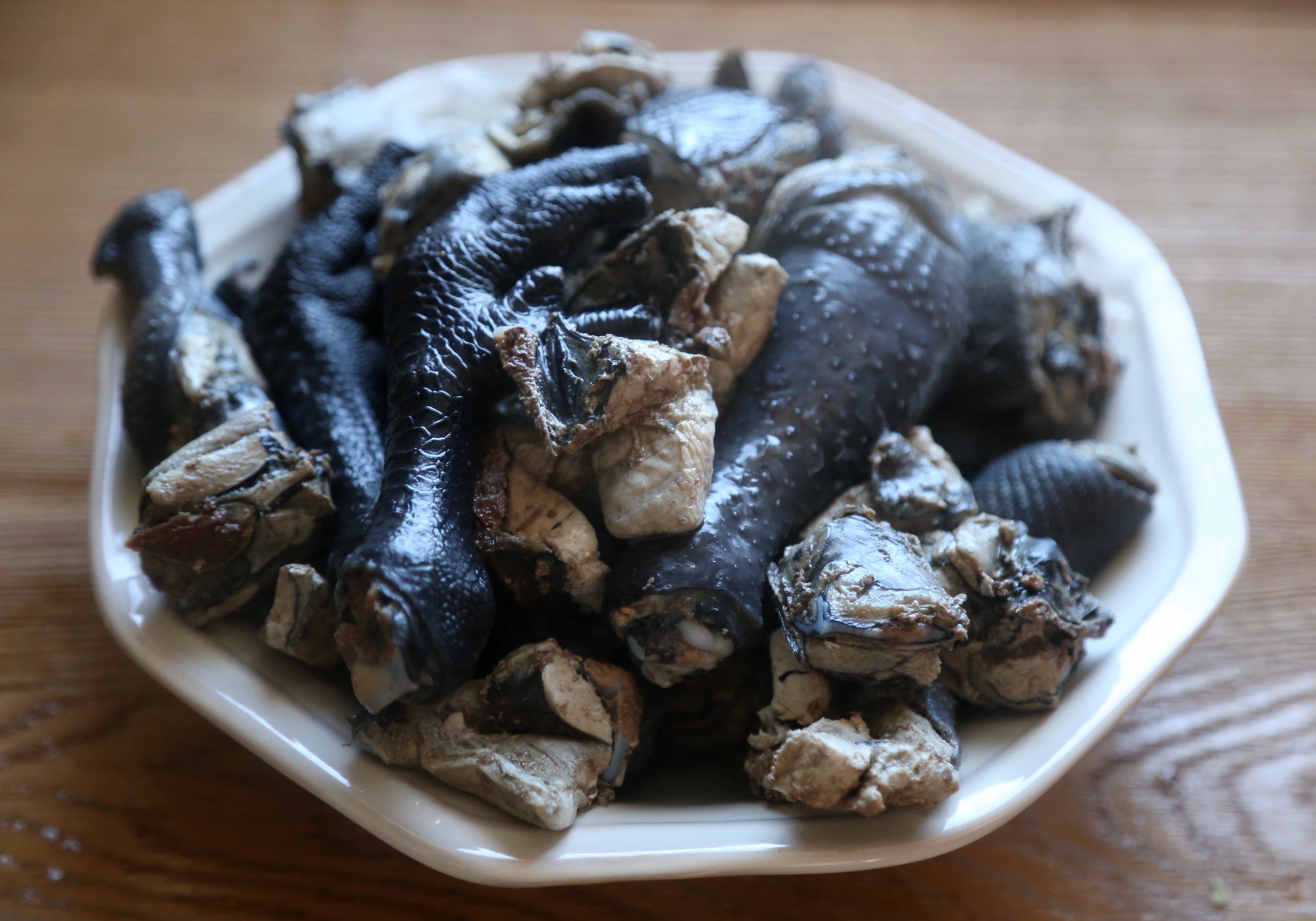 6,砂锅里水烧开,加入乌鸡块,生姜,小葱打结后放入,大火烧开后改小火