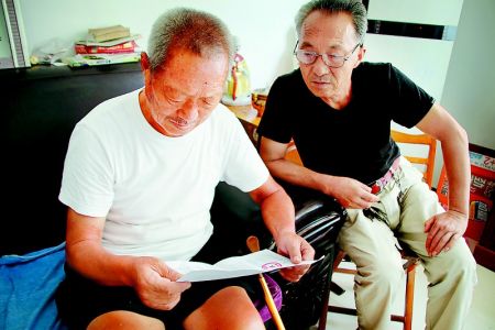 郭承平(左)和弟弟看英烈证明