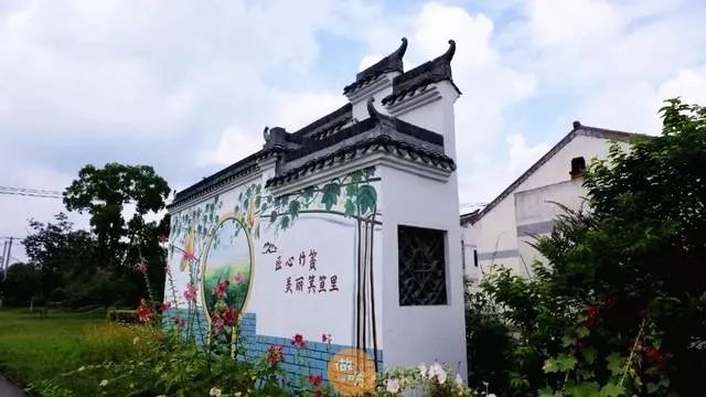 两座大型文化砖墙,一座是绘有"美丽乡村,生态竹箦"的宣传画,一座是