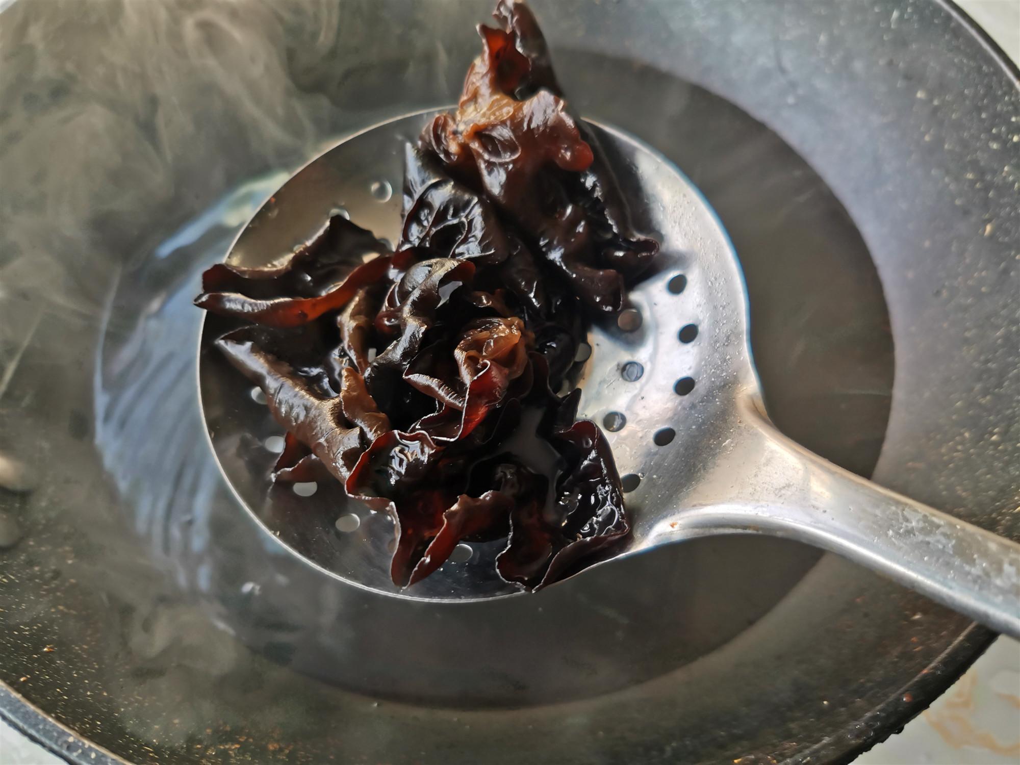 锅内水重新烧开,下入木耳焯水1-2分钟,将木耳捞出,放到冷水中投凉,捞