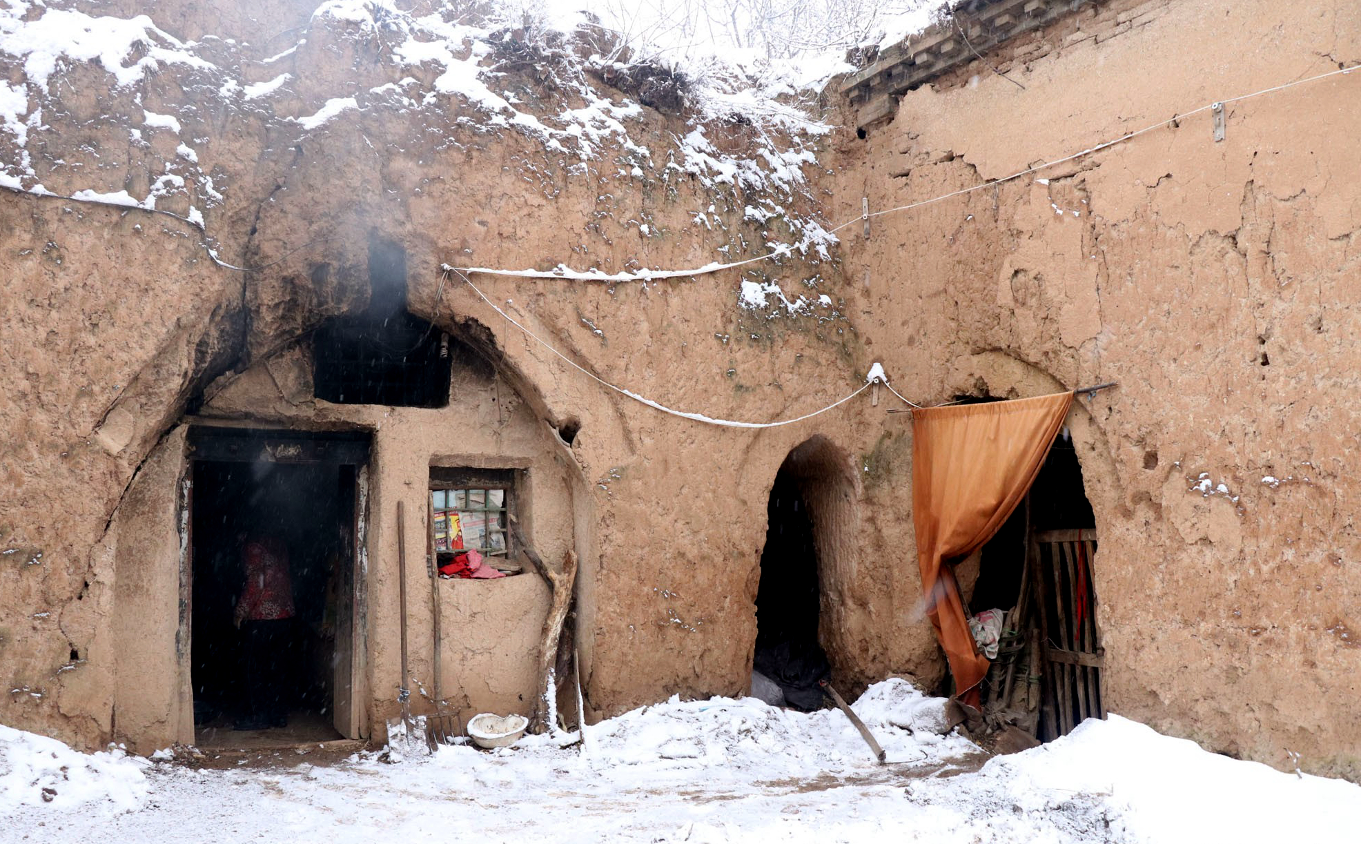 下到地坑院里,大婶已经走进了一孔正往外冒着白烟的窑洞里,她在里面