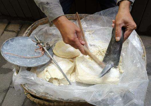 那个时候很多人背着一个背篼,边走边敲边喊:敲麻糖哦!