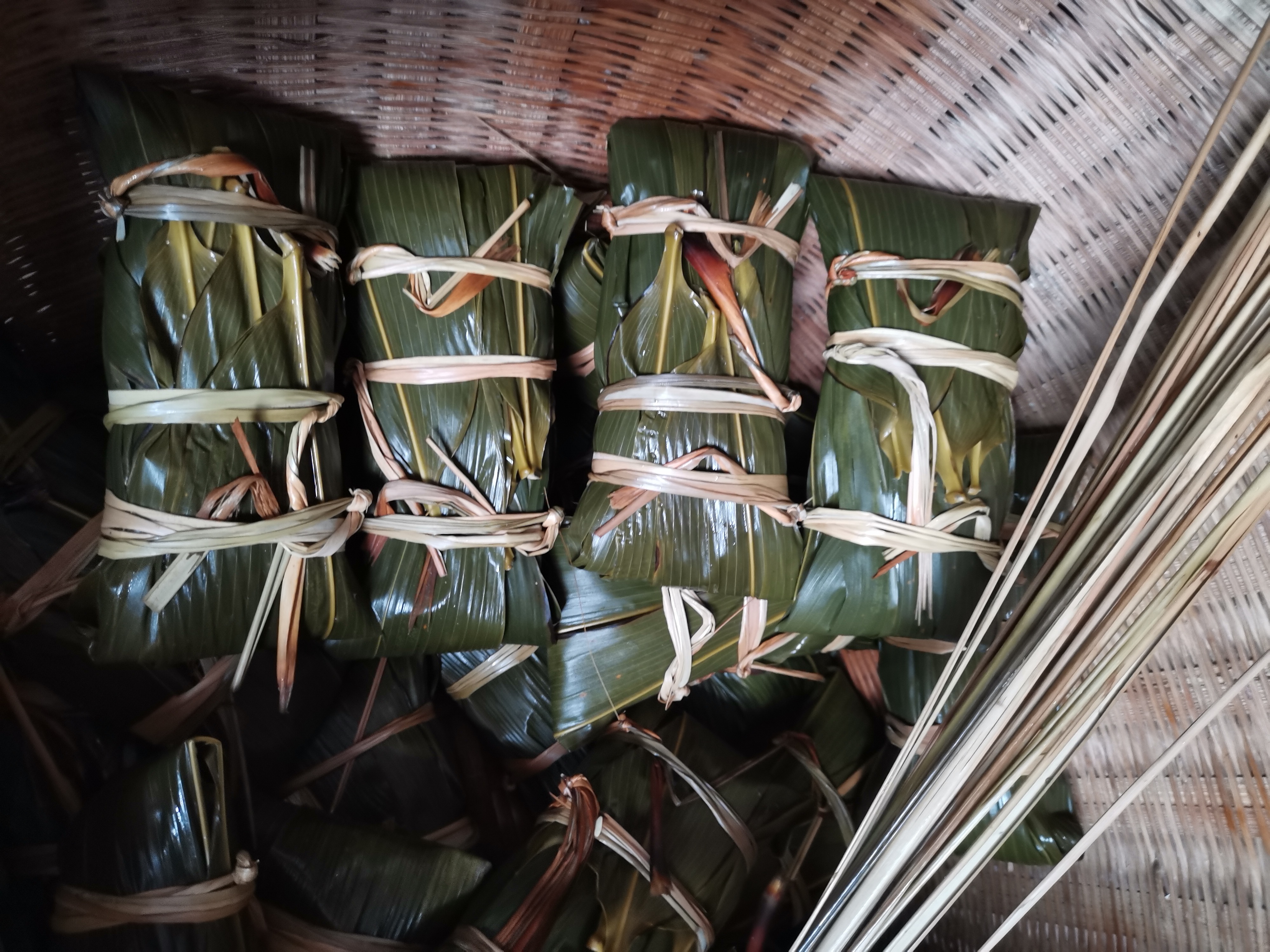 7,包合竹叶,两头的竹叶往中抖到一起,再绑上到一起,再绑上三根绳子.