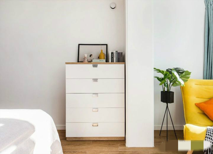 床尾处摆放着一台白色的五斗柜,分类收纳非常方便,主卧阳台设计成了