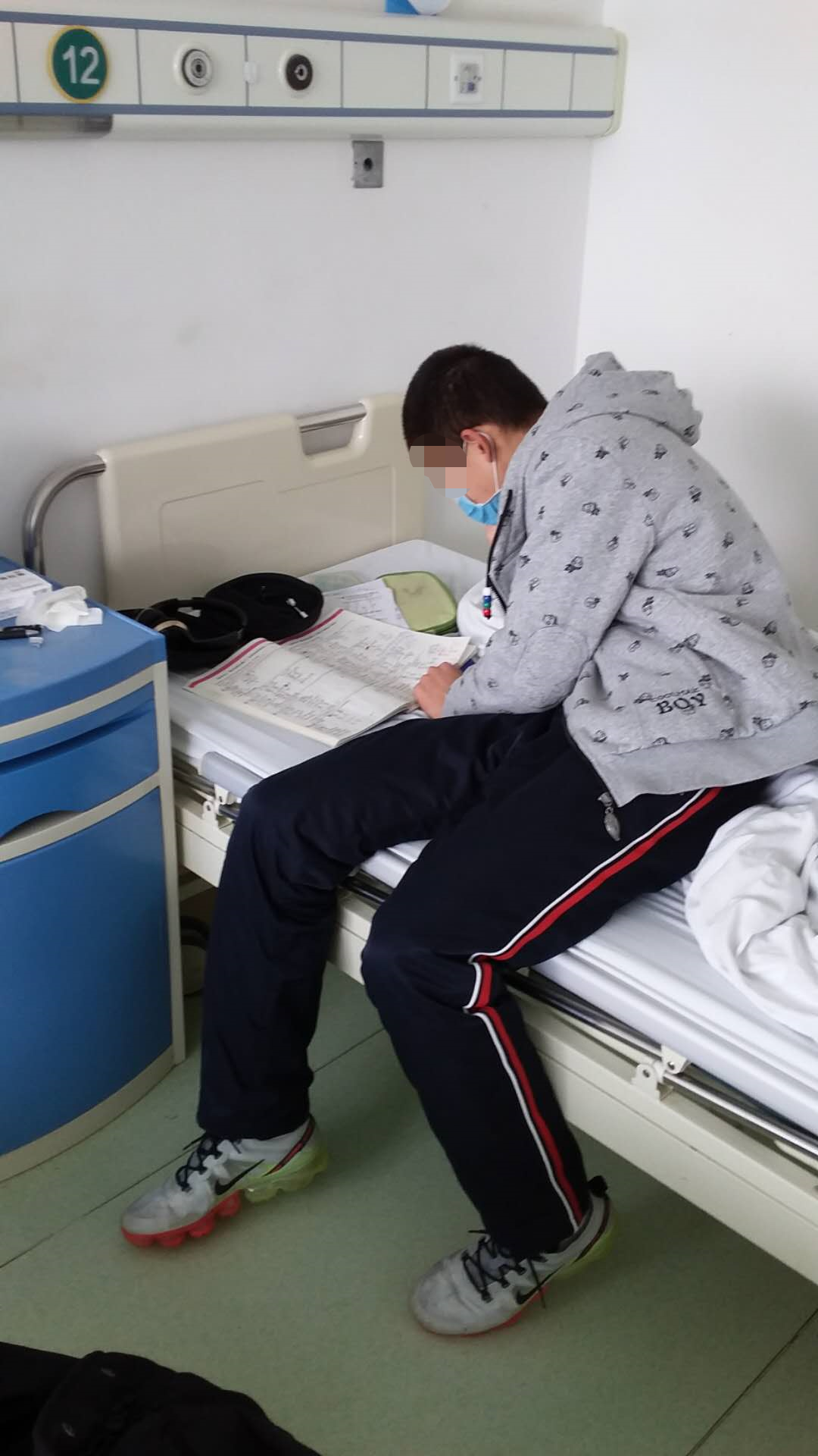 男孩正坐在床上认真学习.