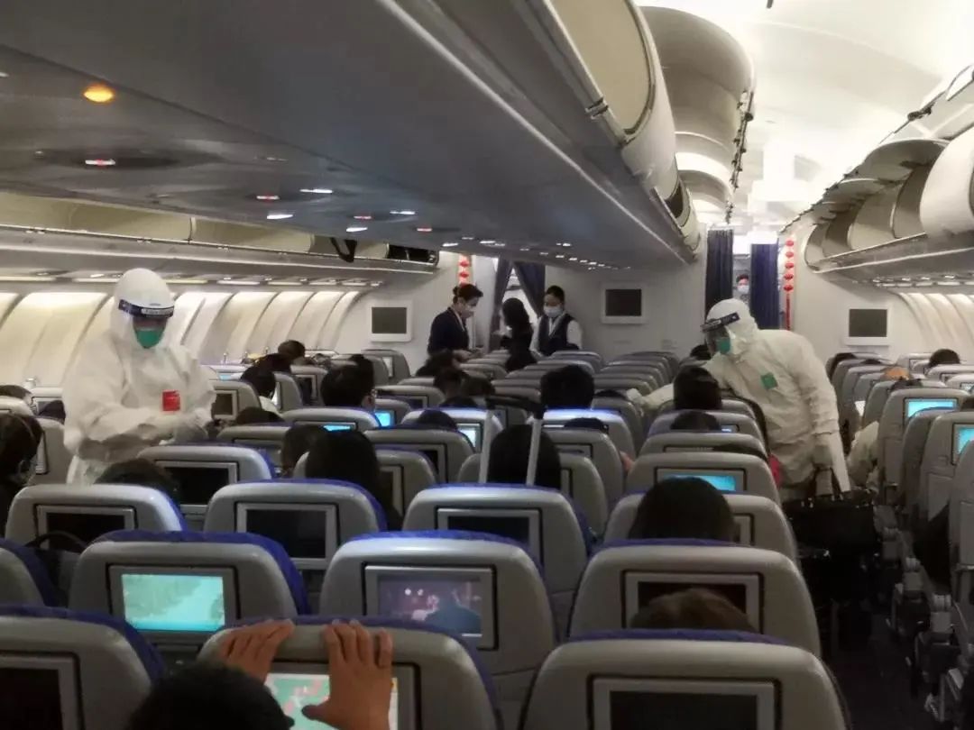 飞机停靠专用廊桥,海关关员向机组人员了解空中测温及旅客健康状况.