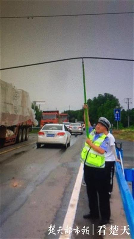 李涛|路过司机纷点赞，交警用撑衣杆托举电线保障交通