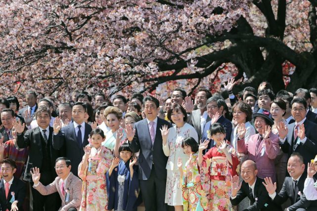 2019年4月13日，安倍和夫人在东京的赏樱花派对上与宾客合影