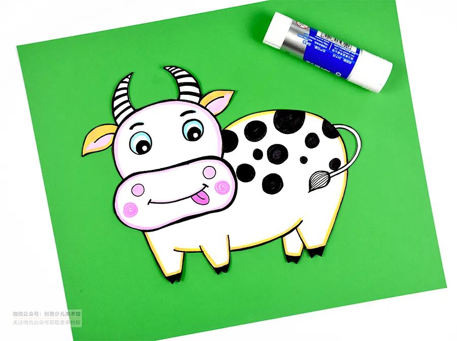 准备一张绿色的卡纸将奶牛剪下来粘贴在绿色的卡纸上围绕奶牛添加高低