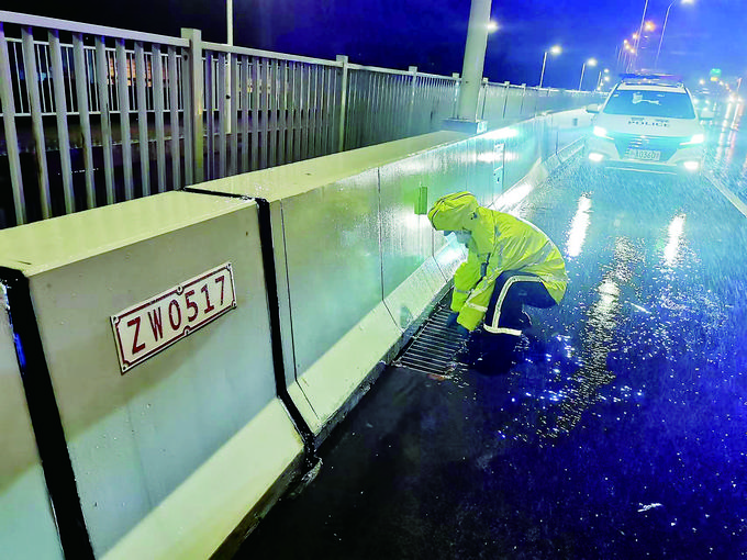 9月4日,上海市公安局交警总队高架支队民警冒雨检查排水情况。张夕 摄